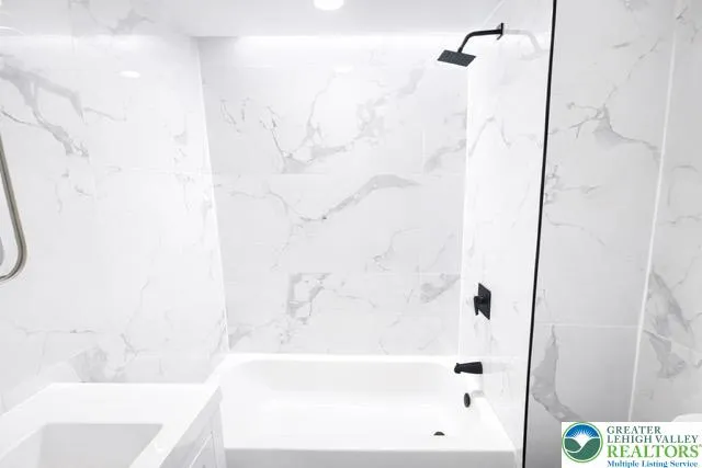 a bathroom with a sink a mirror and shower