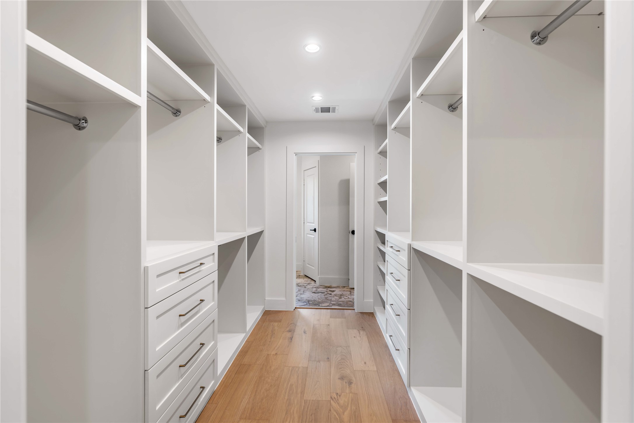 814 Azalea Street Houston, TX 77018 - Photo 17 of 31 Primary closet offering built-in drawers, shelving, and ample hanging space - with direct access to the primary bath and laundry room for effortless convenience