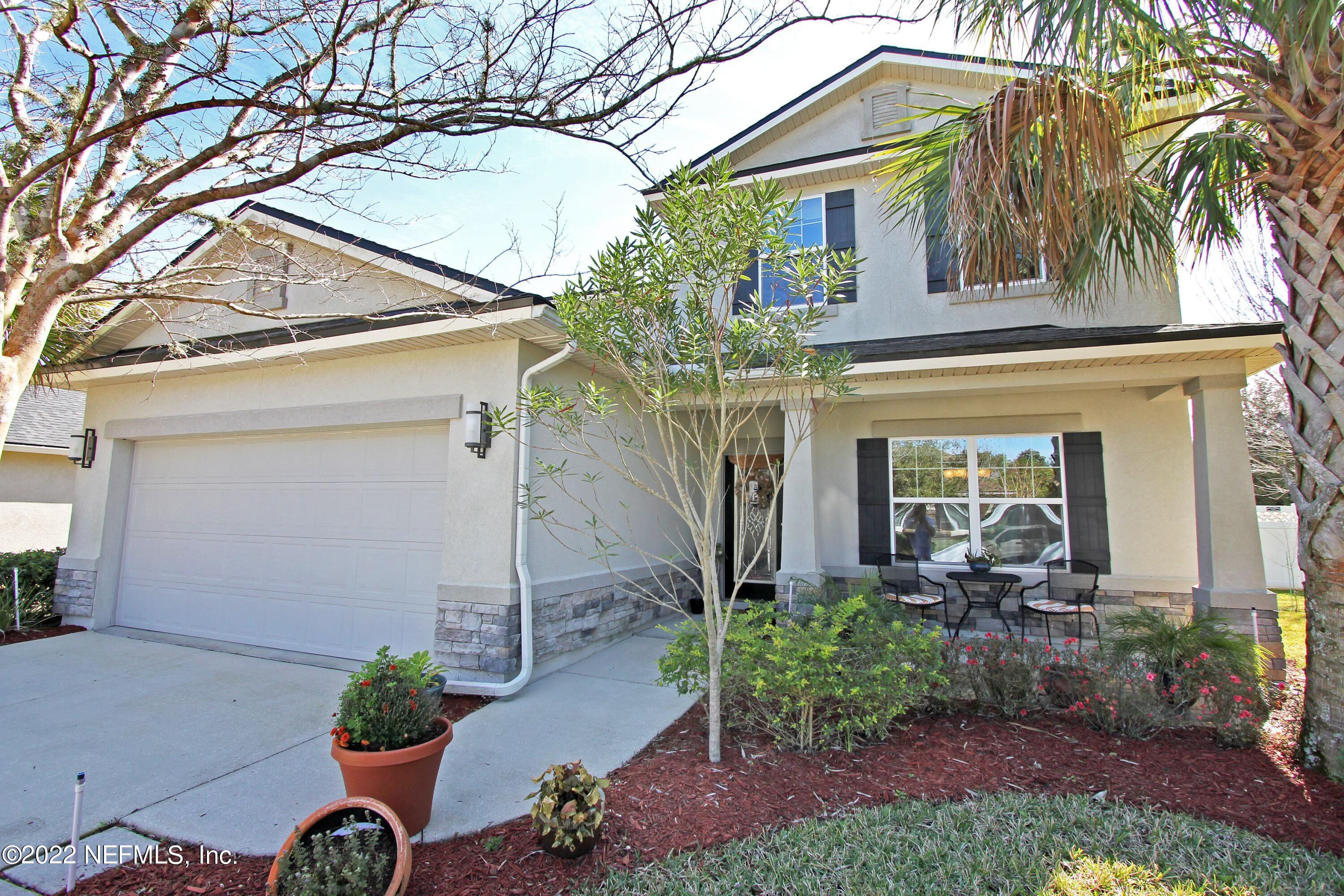 a view of a house with a small yard and a patio