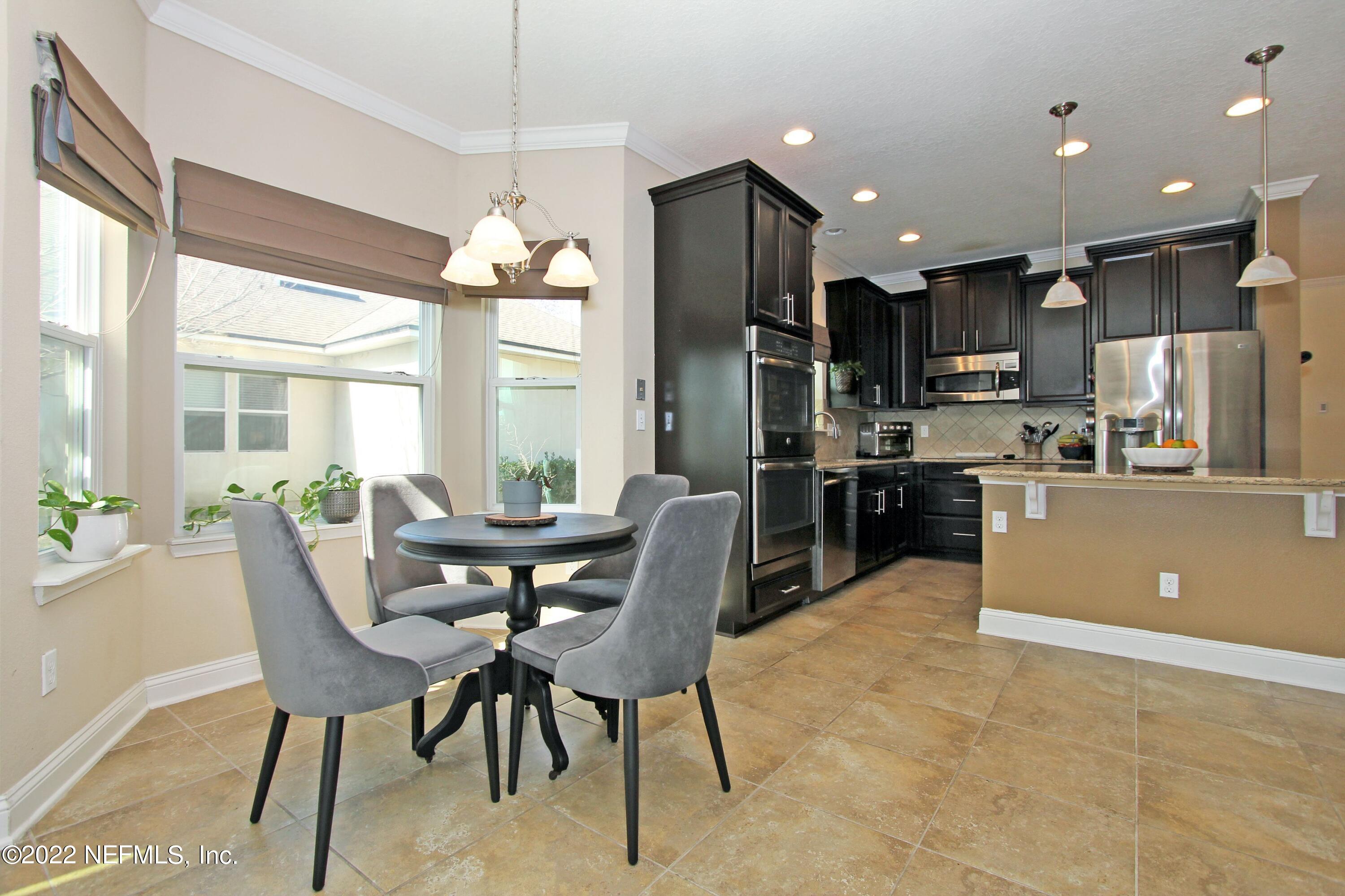 404 Paisley Place St. Johns, FL 32259 - Photo 11 of 42 a dining room with kitchen island stainless steel appliances furniture a chandelier and a view of kitchen