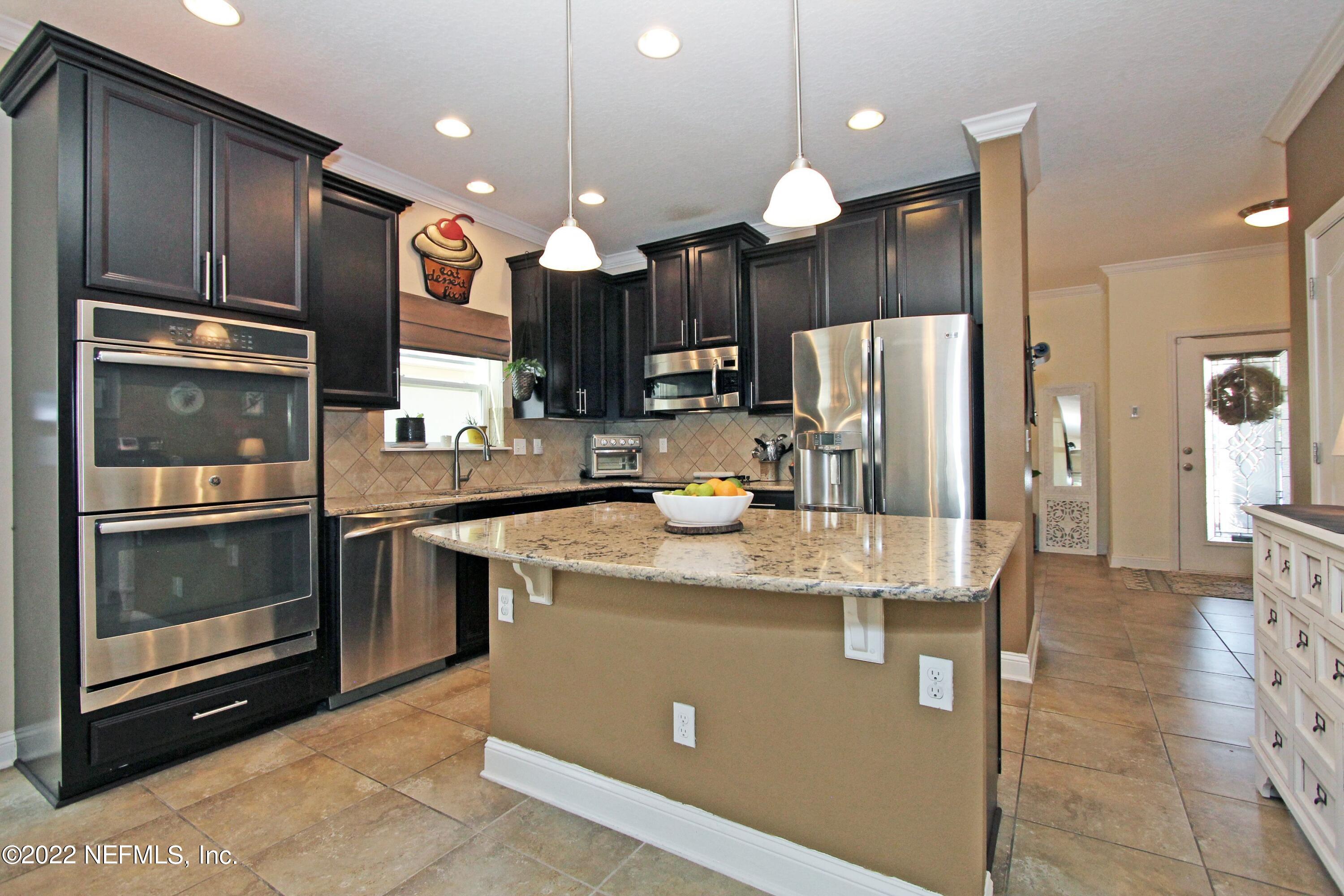 404 Paisley Place St. Johns, FL 32259 - Photo 12 of 42 a kitchen with stainless steel appliances granite countertop a refrigerator a sink and a stove