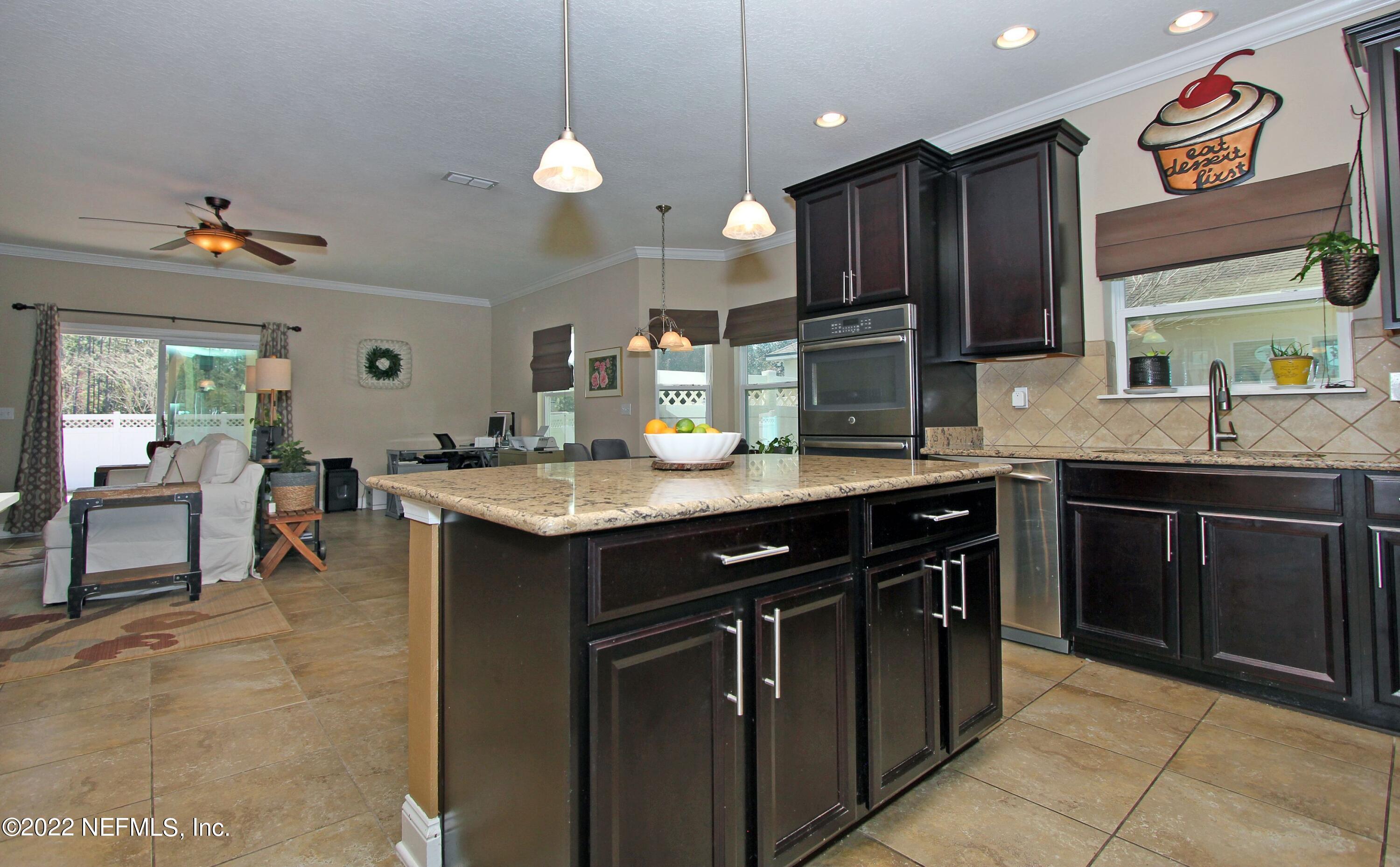 404 Paisley Place St. Johns, FL 32259 - Photo 15 of 42 a kitchen with kitchen island granite countertop a sink counter top space appliances and cabinets