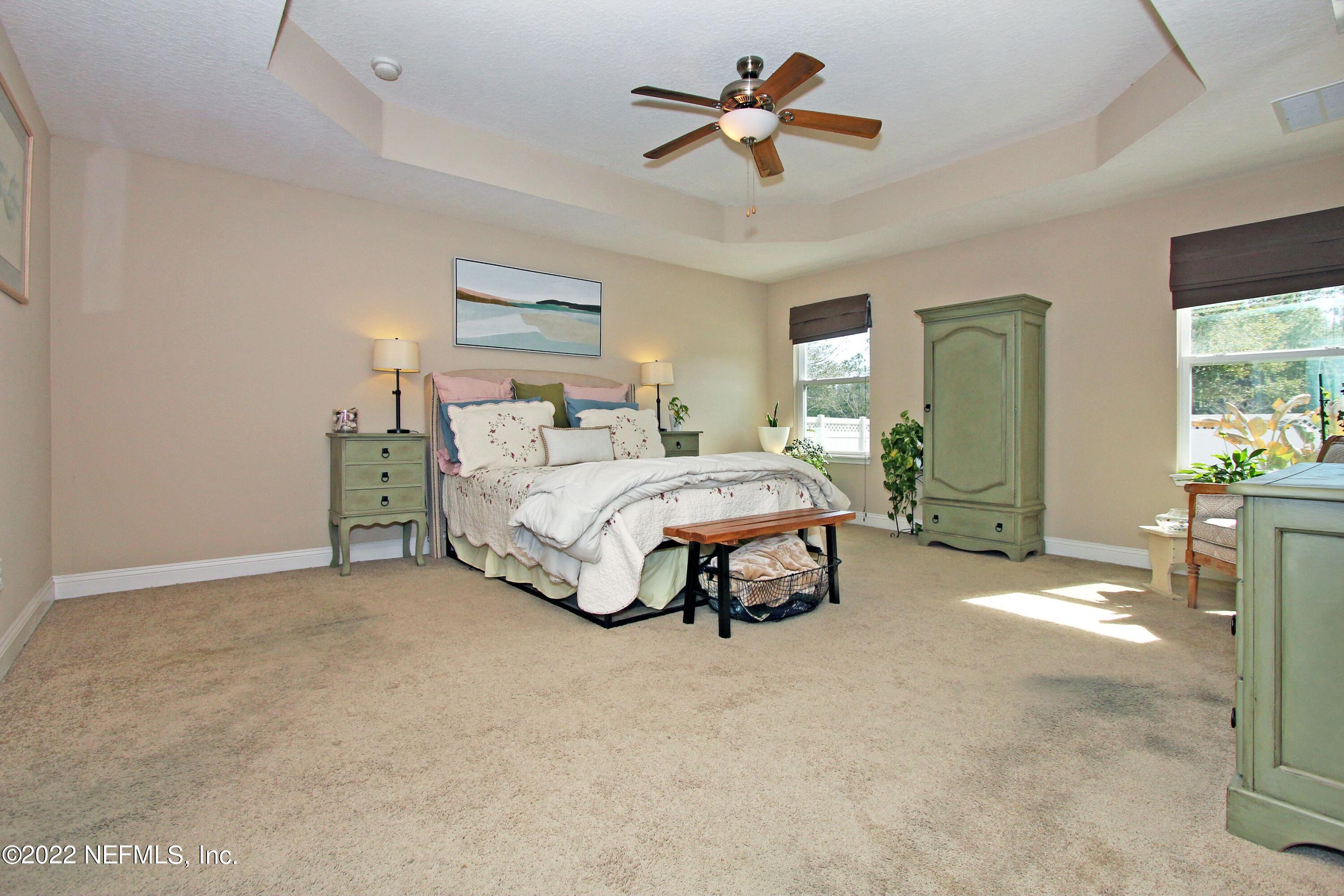 404 Paisley Place St. Johns, FL 32259 - Photo 21 of 42 a spacious bedroom with a bed and a chandelier