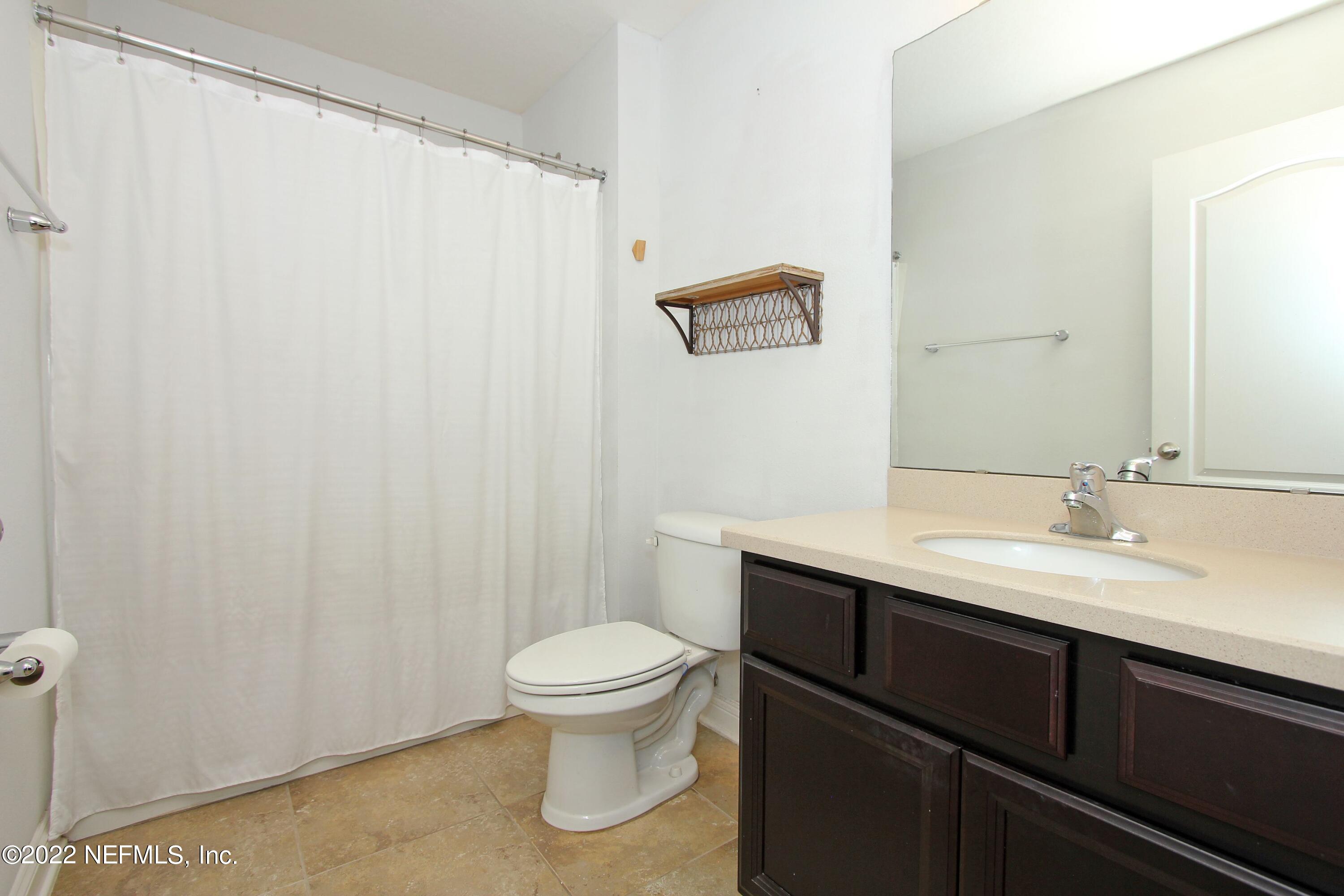 404 Paisley Place St. Johns, FL 32259 - Photo 34 of 42 a bathroom with a sink a toilet a mirror and shower curtain