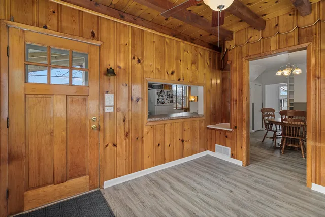 a view of a hallway with wooden floor and a living room