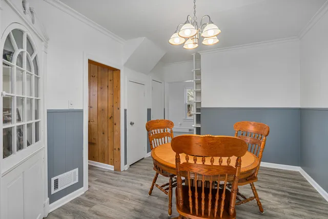 a dining room table chairs and a chandelier