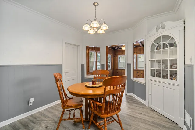 a dining room with furniture a chandelier and wooden floor