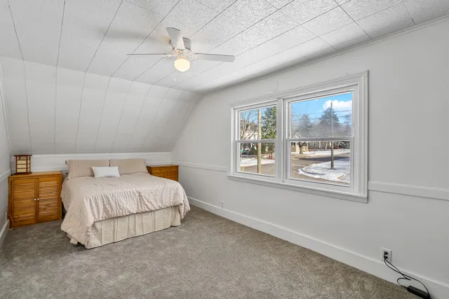 a bedroom with a bed lamp and window