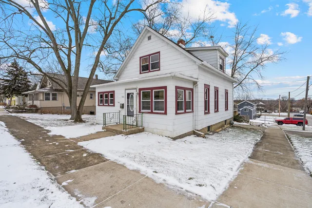 a front view of a house with a yard covered in snow