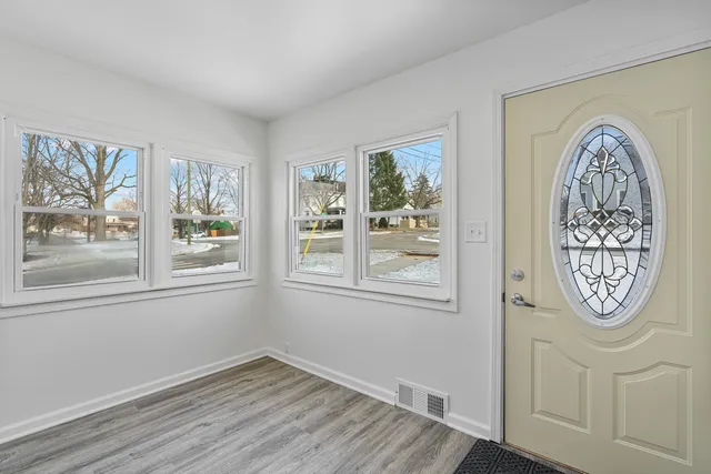 an empty room with a window wooden floor and a rug