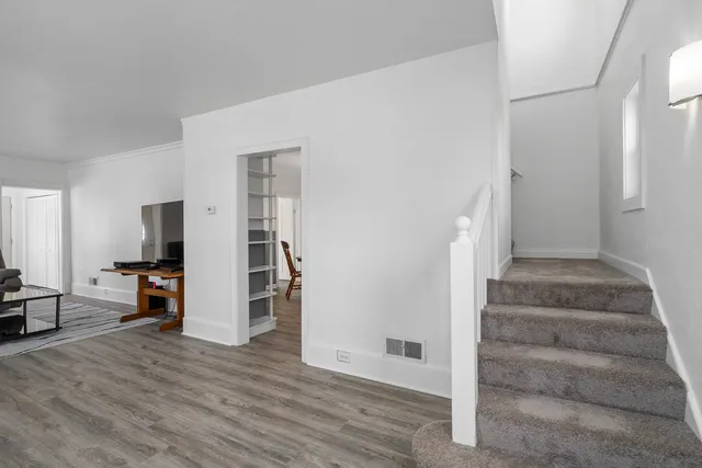 a view of a livingroom with wooden floor and furniture