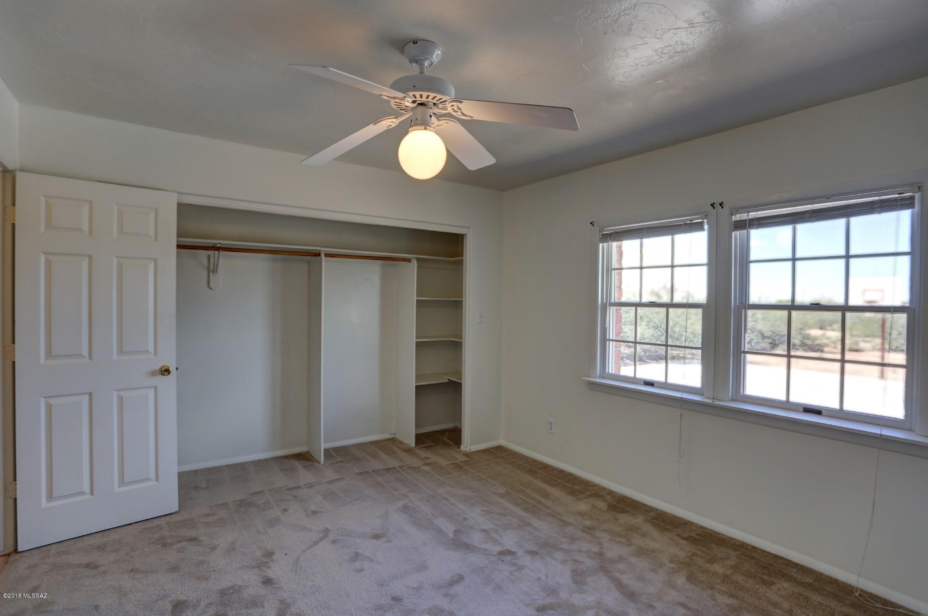 5851 South Avra Road Tucson, AZ 85735 - Photo 33 of 46 an empty room with windows and chandelier fan