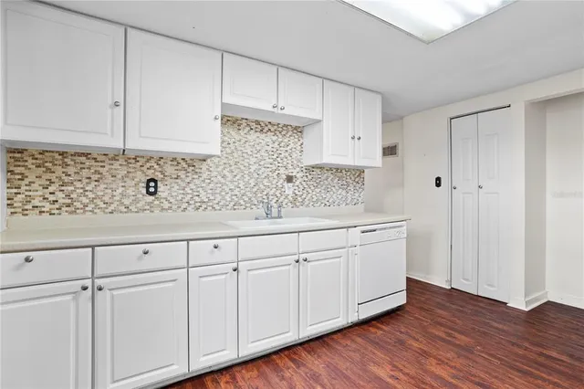 a kitchen with white cabinets white countertops and white appliances