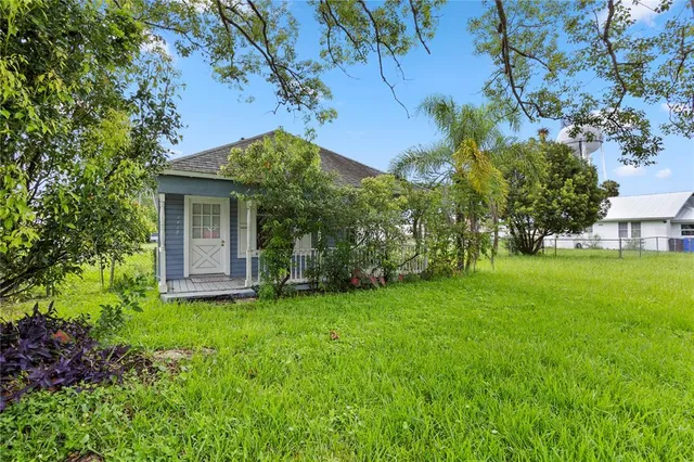 a view of a backyard with table and chairs and potted plants