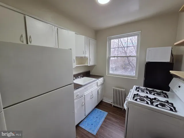 a kitchen with stainless steel appliances a white stove top oven sink and cabinets