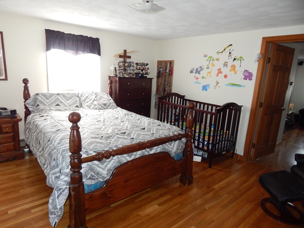 274 Athens Street Boston, MA 02127 - Photo 17 of 23 a bedroom with a bed and wooden floor