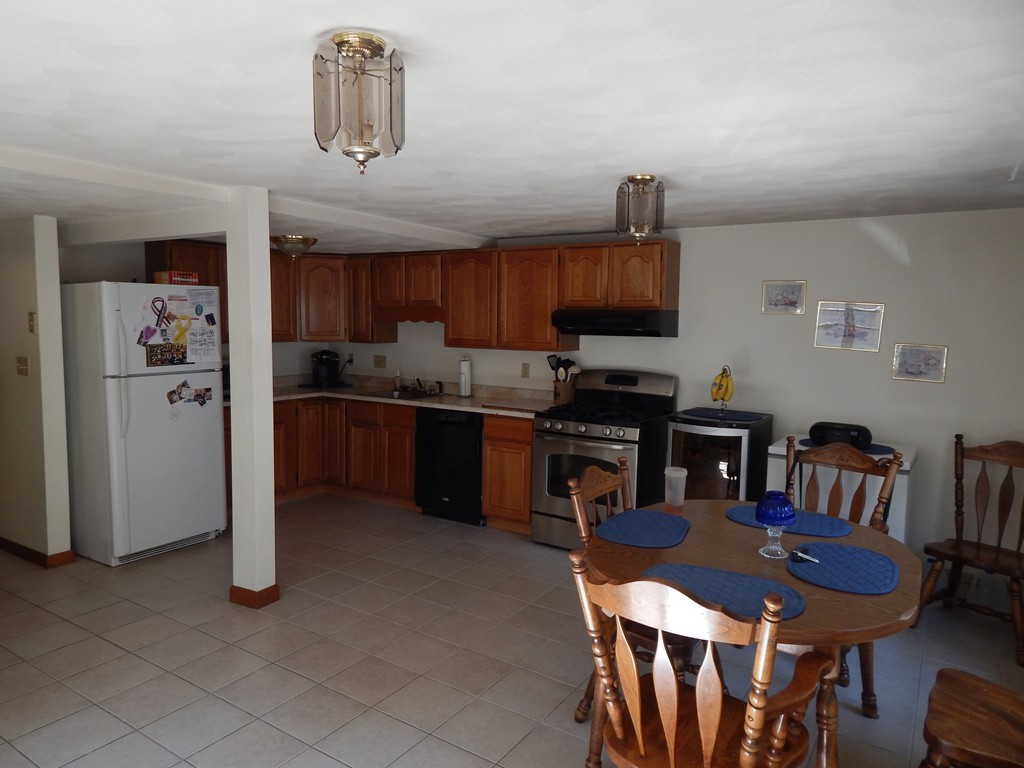 274 Athens Street Boston, MA 02127 - Photo 9 of 23 a kitchen with a dining table chairs and a refrigerator