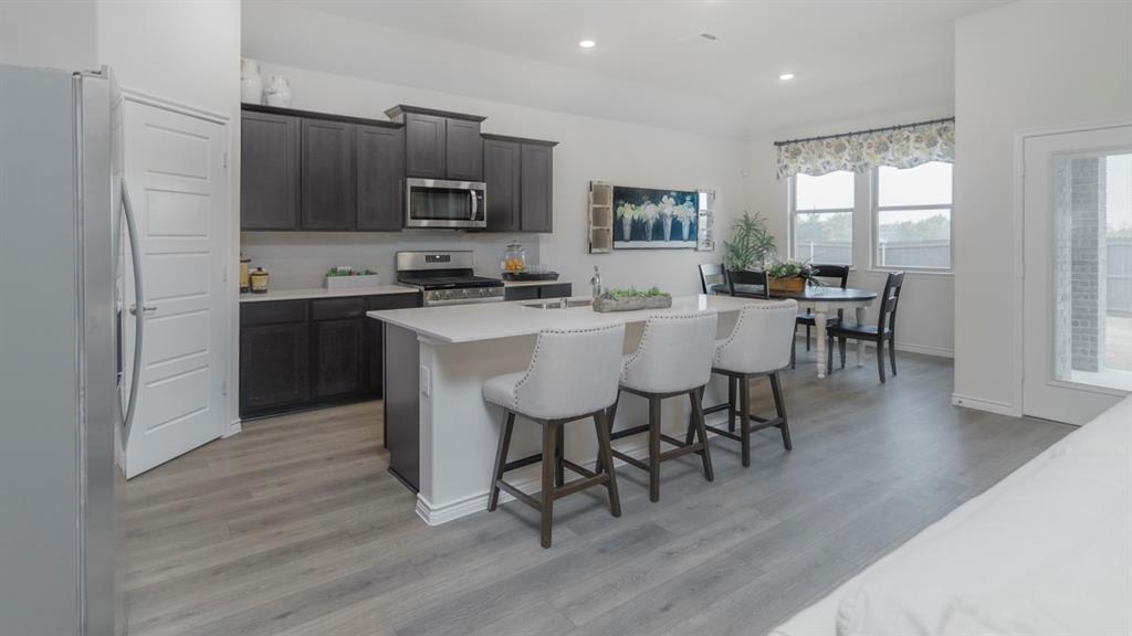 503 Range Road Caddo Mills, TX 75135 - Photo 7 of 19 Kitchen featuring stainless steel appliances, an island with sink, a breakfast bar area, recessed lighting, and light wood finished floors