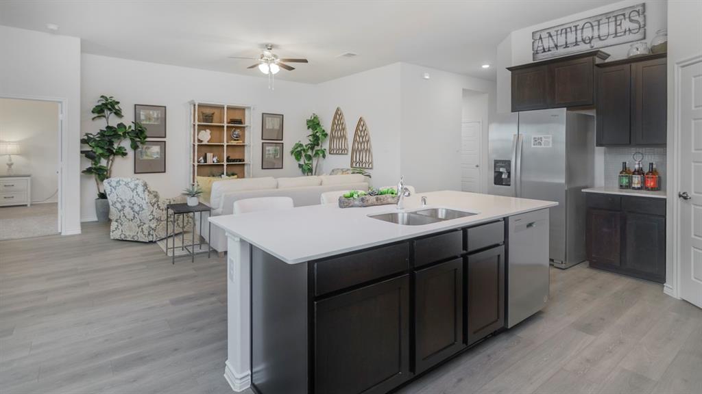 503 Range Road Caddo Mills, TX 75135 - Photo 18 of 19 Kitchen featuring dark wood finish cabinets, stainless steel appliances, ceiling fan, light wood-style floors, and open floor plan