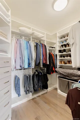 a view of walk in closet with clothes and shoes
