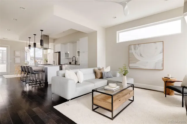 a living room with furniture wooden floor and a large window