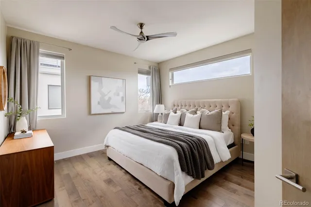 a bedroom with a large bed and two windows