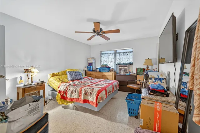 a bedroom with bed a flat tv screen and a dresser