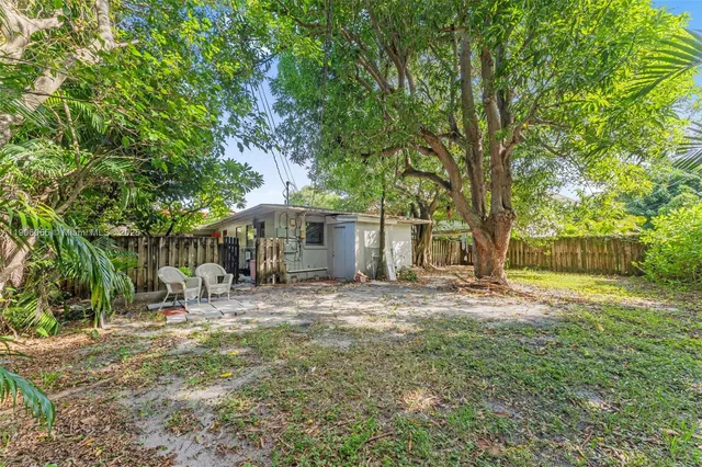 a backyard of a house with table and chairs