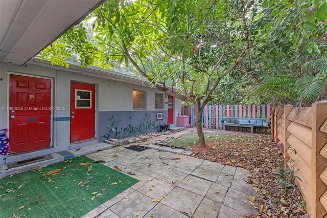 a view of backyard with wooden fence and large trees