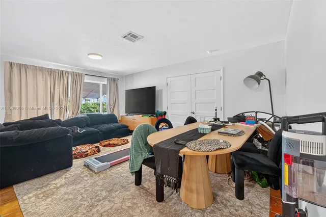 a living room with furniture a flat screen tv and a window