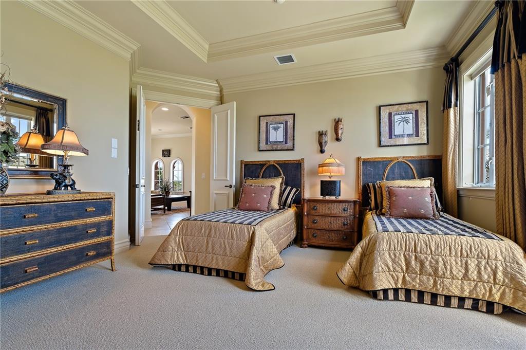 1025 Northeast Doubloon Drive Stuart, FL 34996 - Photo 23 of 69 a bedroom with two beds and a chandelier