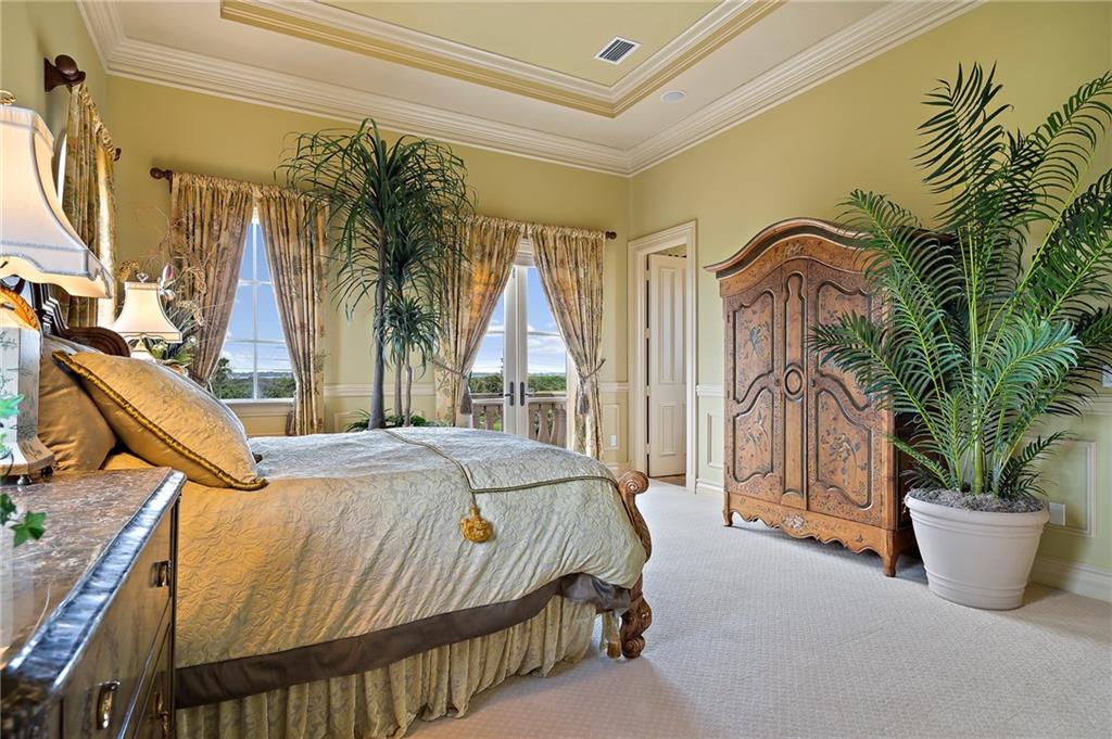 1025 Northeast Doubloon Drive Stuart, FL 34996 - Photo 26 of 69 a bedroom with a bed a potted plant and a large window