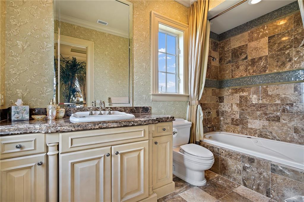 1025 Northeast Doubloon Drive Stuart, FL 34996 - Photo 27 of 69 a bathroom with a granite countertop sink toilet mirror and bathtub