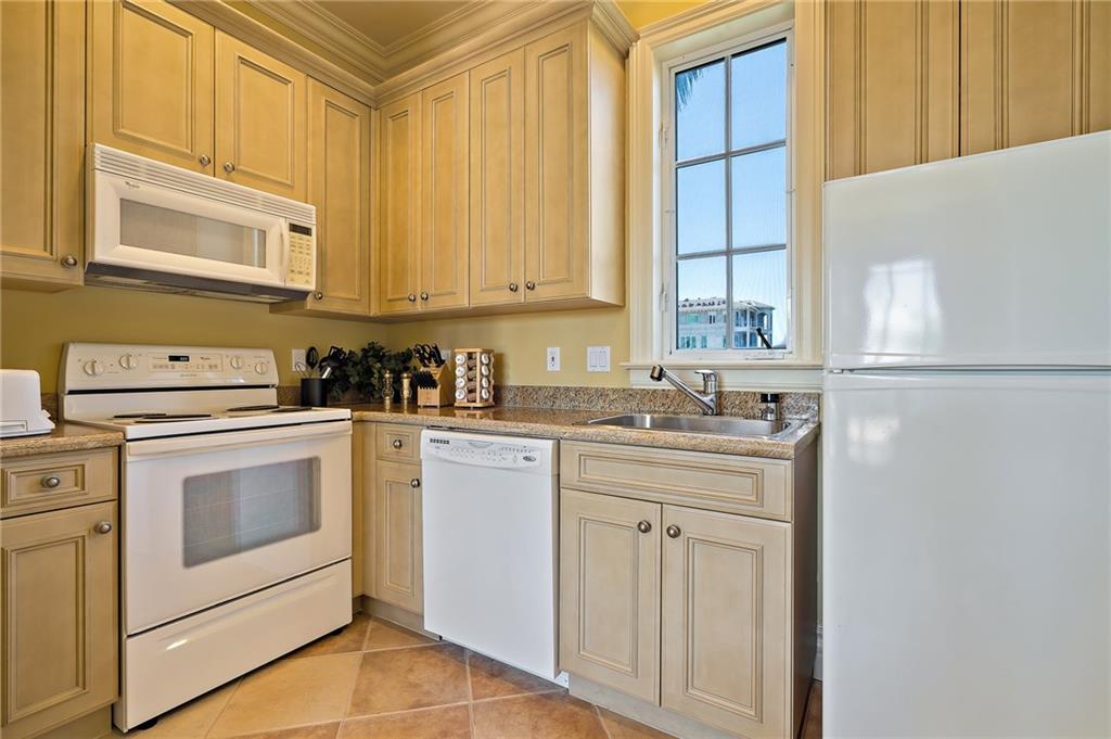 1025 Northeast Doubloon Drive Stuart, FL 34996 - Photo 59 of 69 a kitchen with white cabinets and white appliances