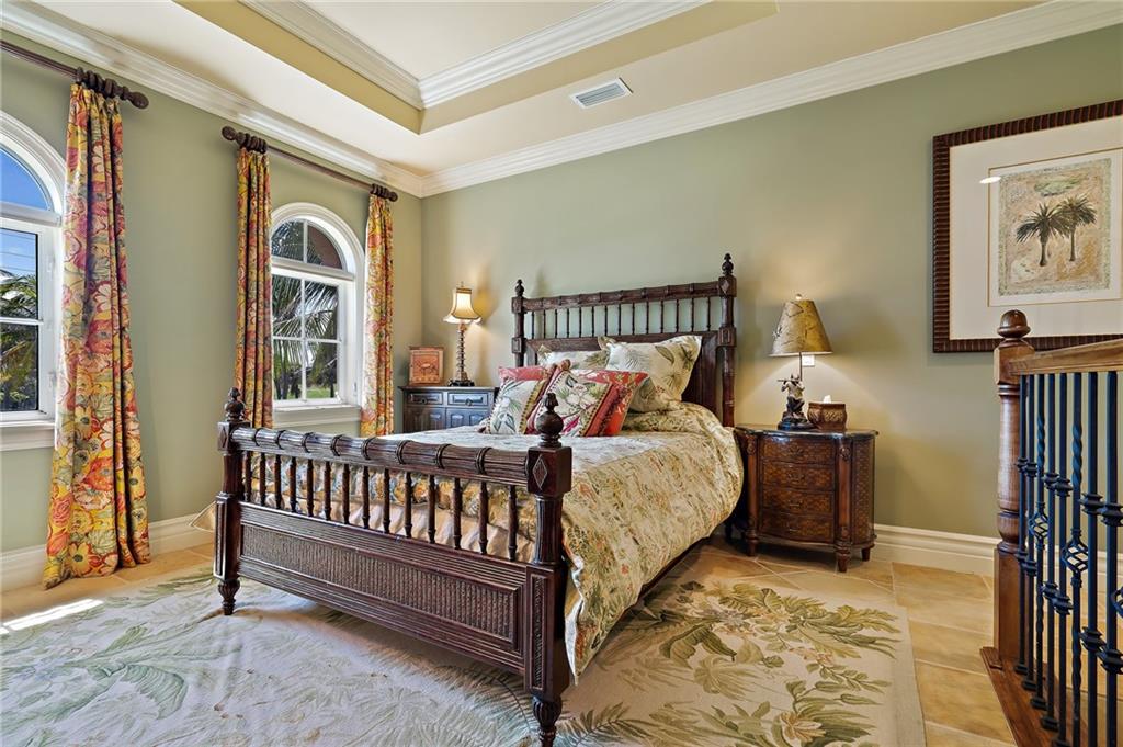1025 Northeast Doubloon Drive Stuart, FL 34996 - Photo 62 of 69 a bed sitting in a bedroom next to a window
