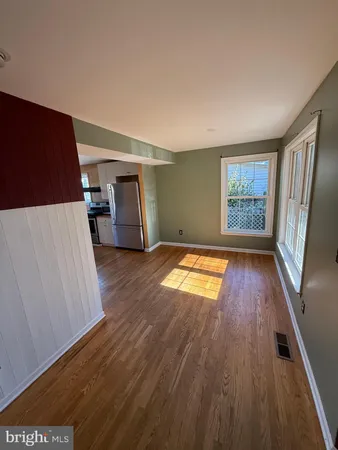 a view of empty room with wooden floor and window
