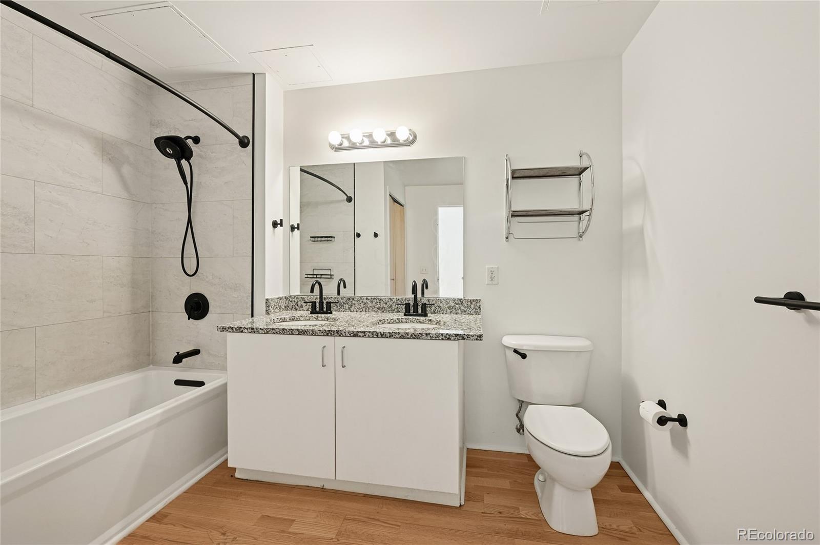 3100 Huron Street, Unit 2C Denver, CO 80202 - Photo 16 of 18 a bathroom with a granite countertop sink a toilet and bathtub
