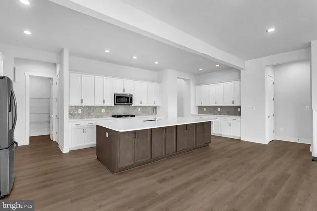 a large kitchen with stainless steel appliances granite countertop a large counter top and a stove top oven