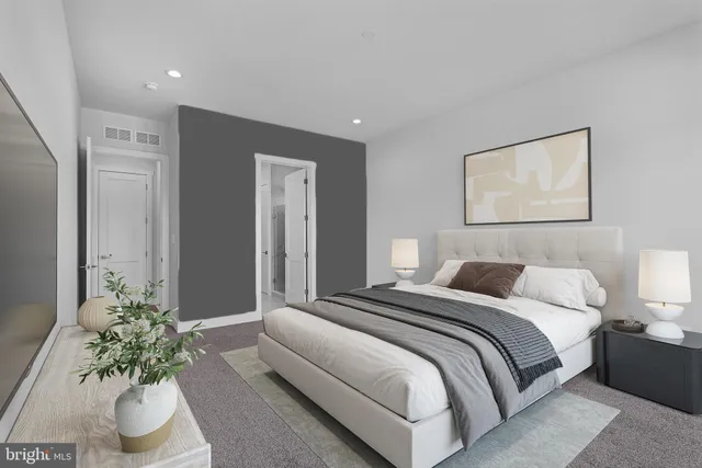 a bedroom with a large bed and a potted plant