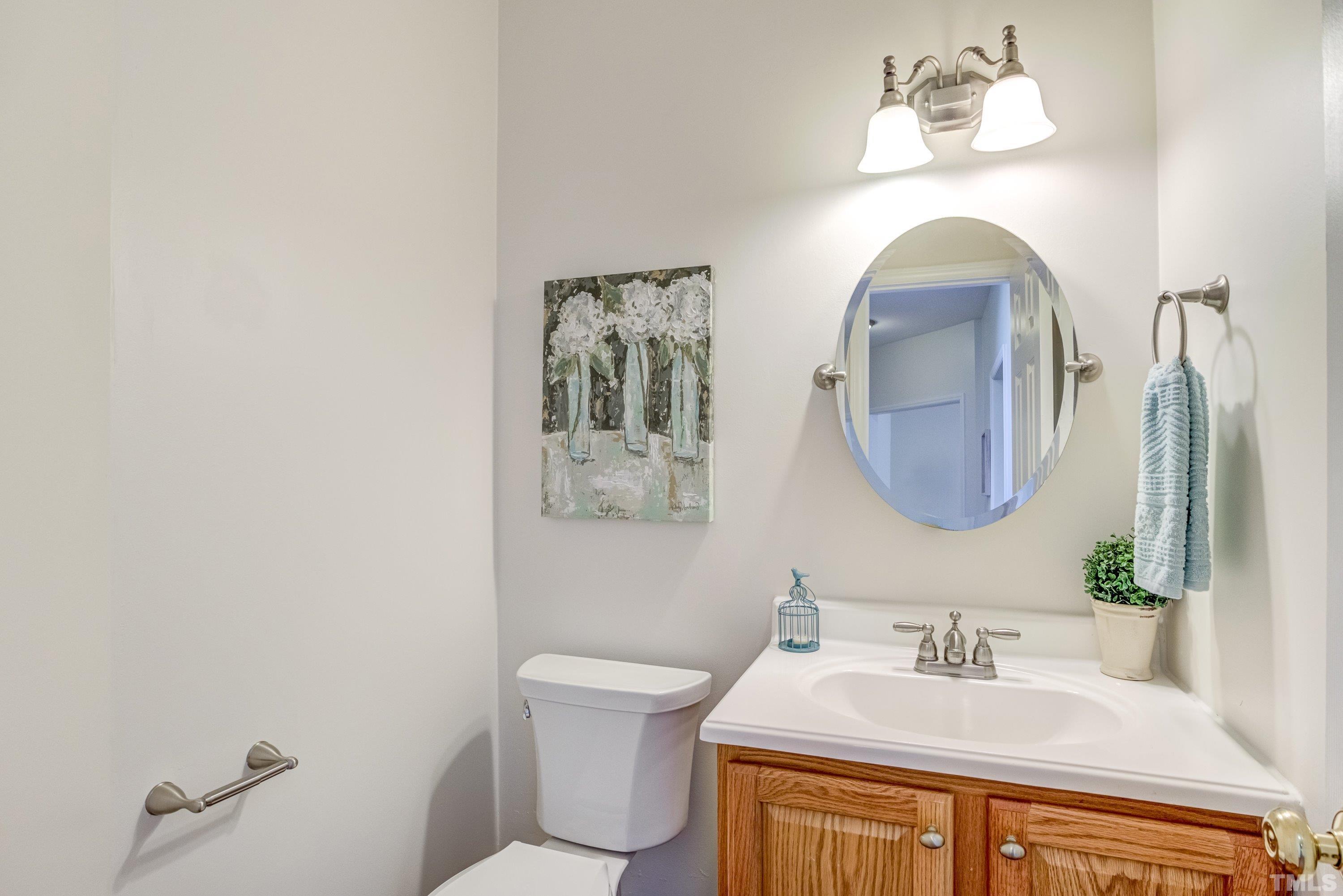 467 Seastone Street Raleigh, NC 27603 - Photo 20 of 38 a bathroom with a toilet sink and mirror