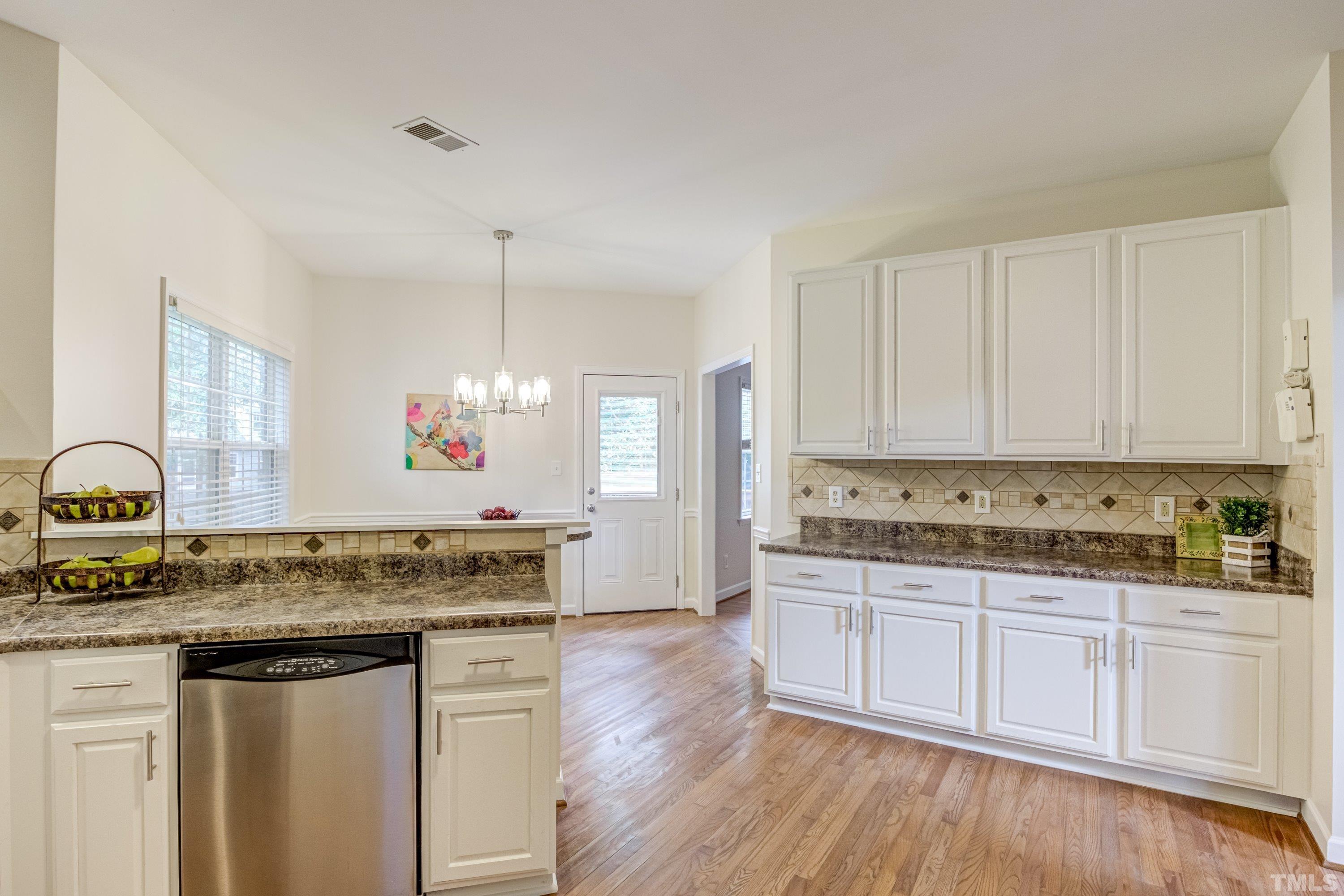 467 Seastone Street Raleigh, NC 27603 - Photo 5 of 38 a kitchen with stainless steel appliances granite countertop a stove and white cabinets