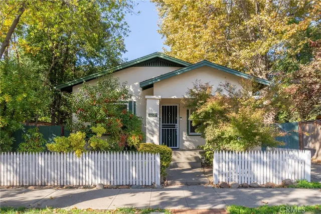 a view of a house with a small yard and wooden fence