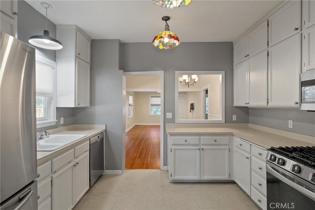 1158 East 7th Street Chico, CA 95928 - Photo 11 of 41 a kitchen with a sink dishwasher a stove and a refrigerator