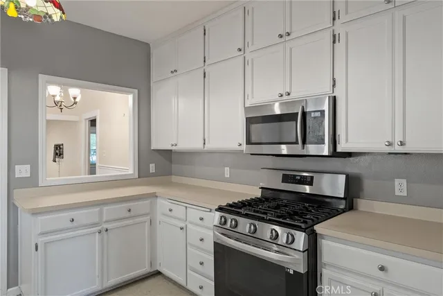 a kitchen with granite countertop white cabinets and stainless steel appliances