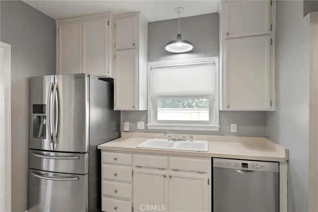 a kitchen with a refrigerator sink and cabinets