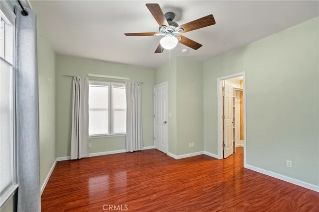 a view of a livingroom with wooden floor and a ceiling fan