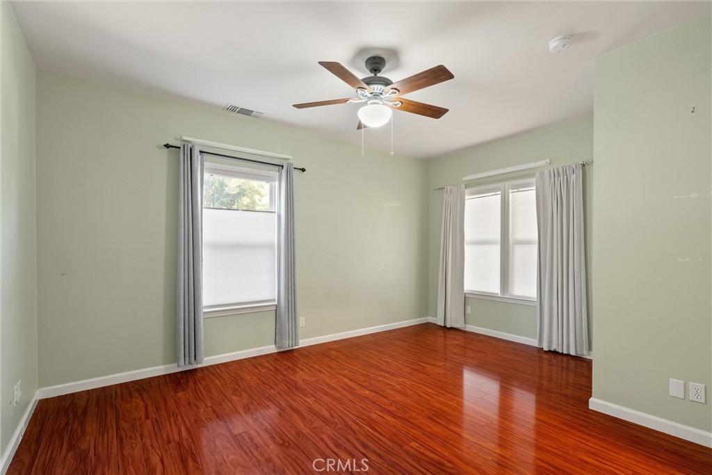 1158 East 7th Street Chico, CA 95928 - Photo 19 of 41 an empty room with wooden floor fan and windows