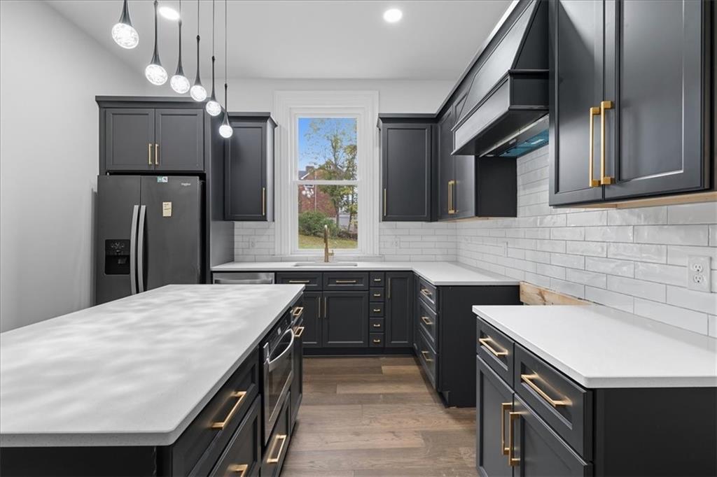 205 Spring Street Oakdale, PA 15071 - Photo 13 of 50 a kitchen with a sink dishwasher a stove and a refrigerator with wooden floor