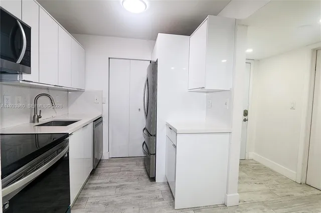 a kitchen with a sink appliances and cabinets