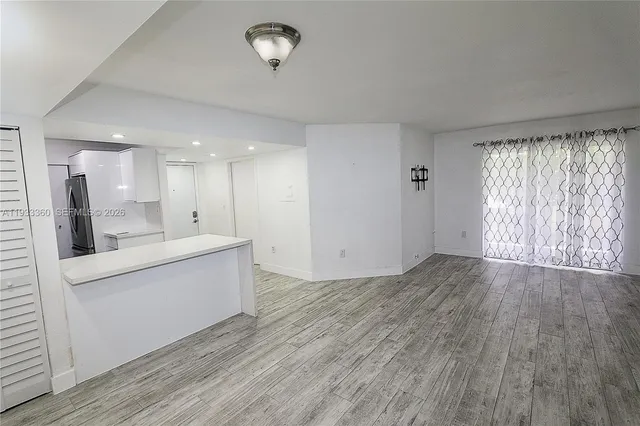 a view of kitchen with wooden floor and electronic appliances